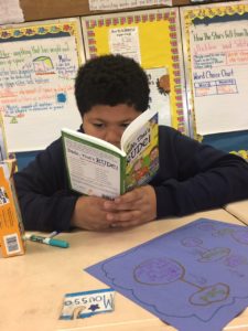 A student reads a book with great focus